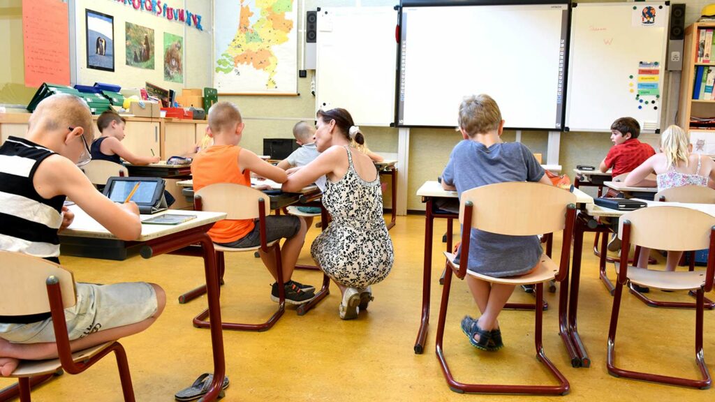 Teacher helping a student with work in a classroom