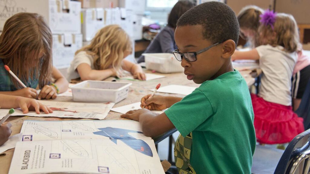 Student in classroom with peers working on classwork